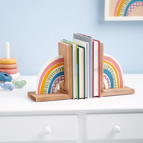 A cheerful set of coordinating bookends displaying a double-sided design of a rainbow that flows from one bookend to the other.